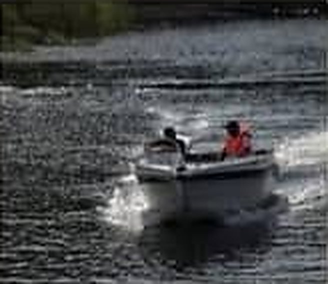 Two people on a speed boat cutting across the lake